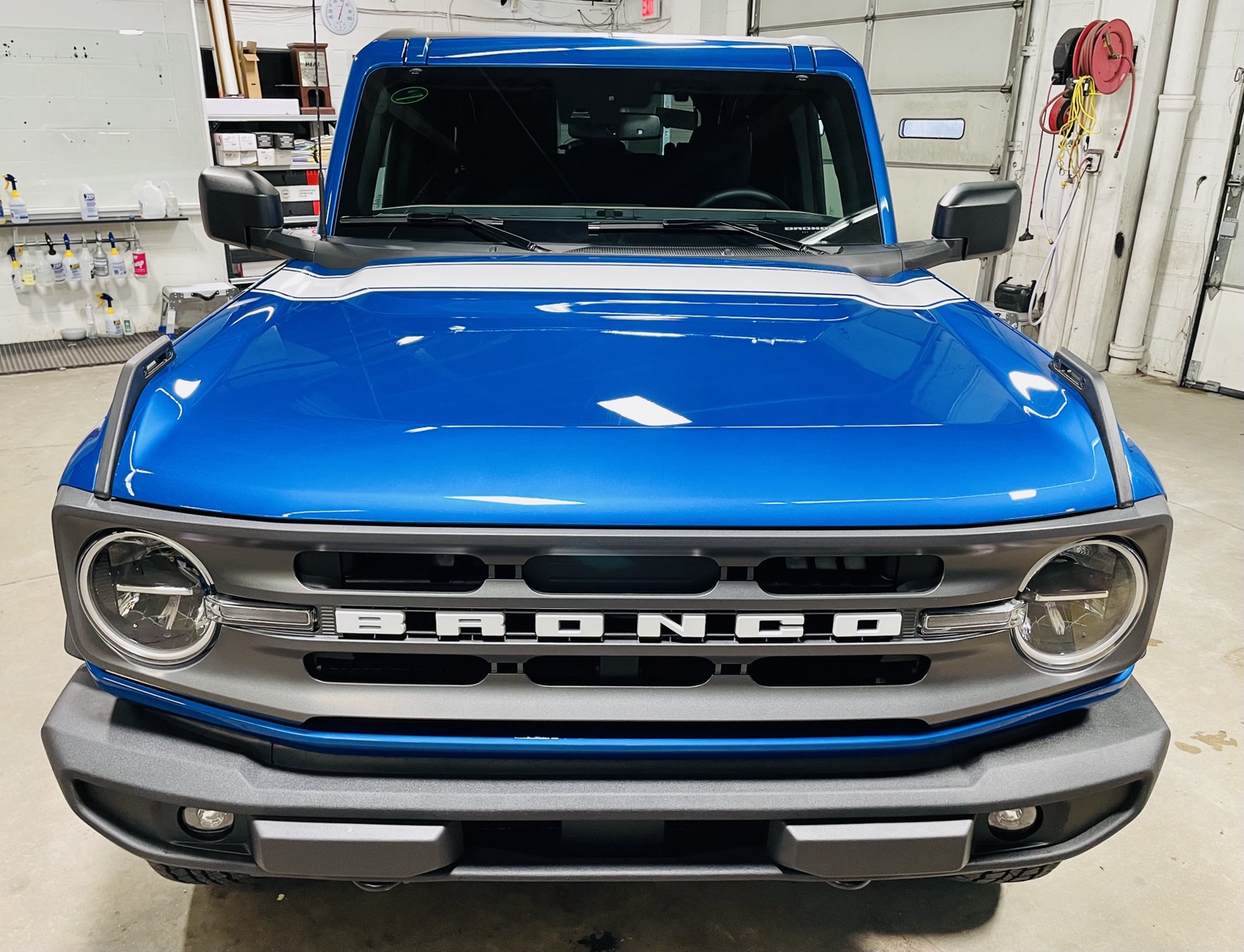 Blue Ford Bronco shown head-on inside the shop
