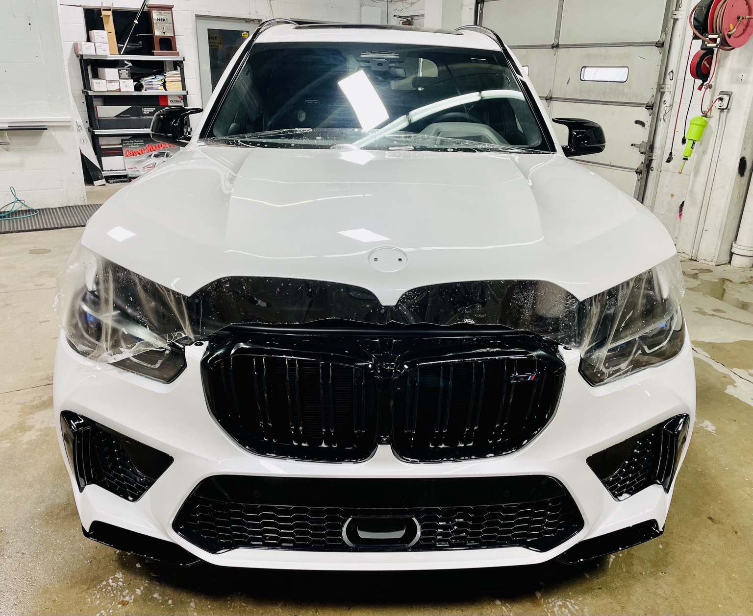 White BMW X5 M Competition during front-end paint protection film installation