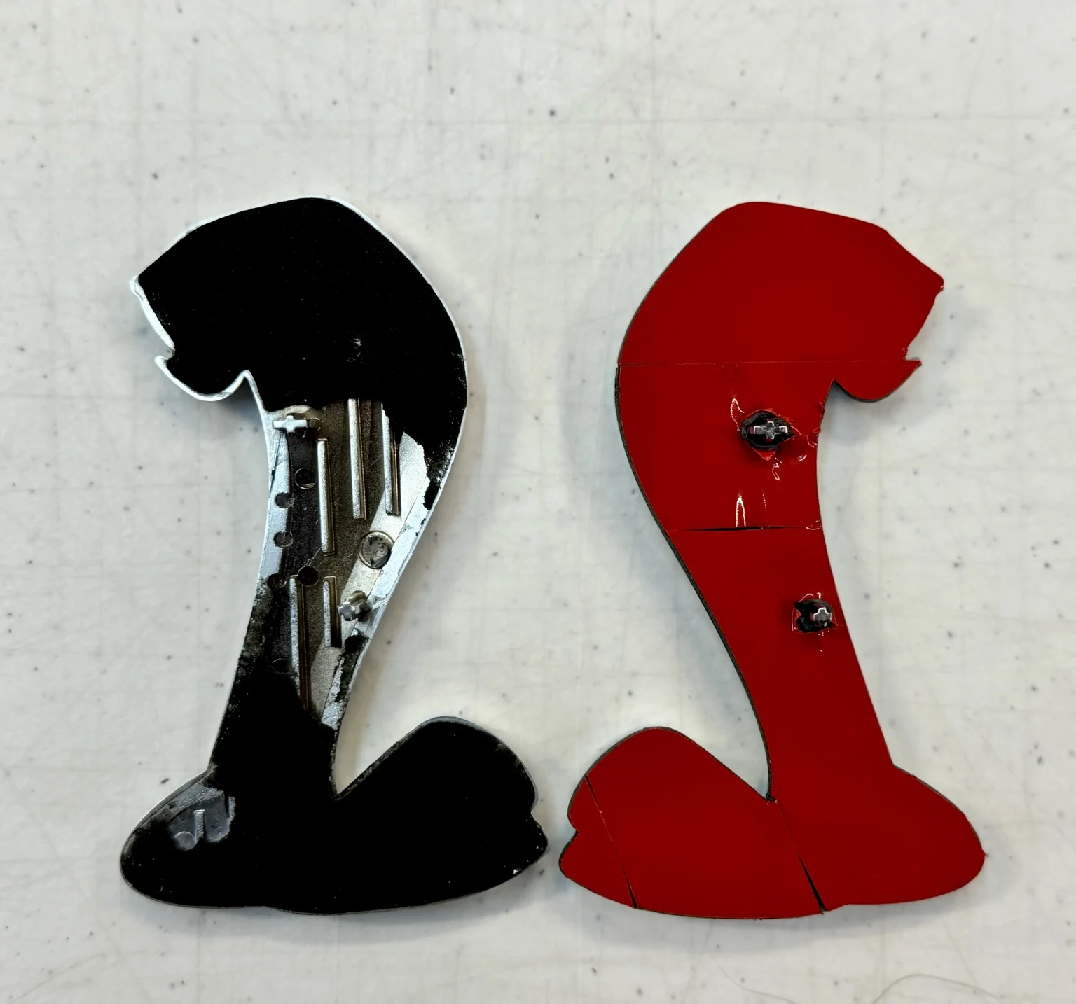 Backs of the original Cobra badges prepared with new mounting tape, including red release liner