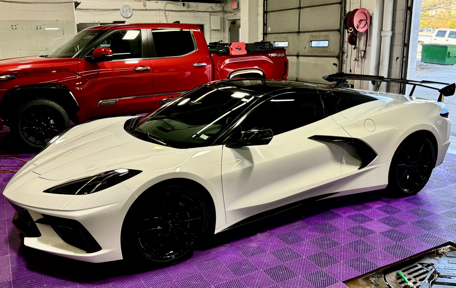White C8 Corvette shown from the front in the installation shop