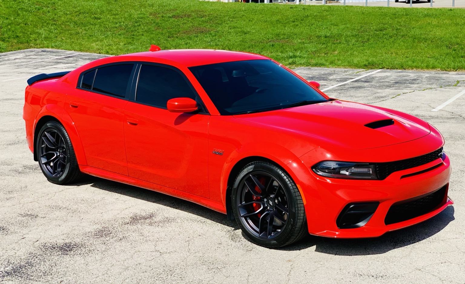 Red Dodge Charger with tinted windows outside the shop