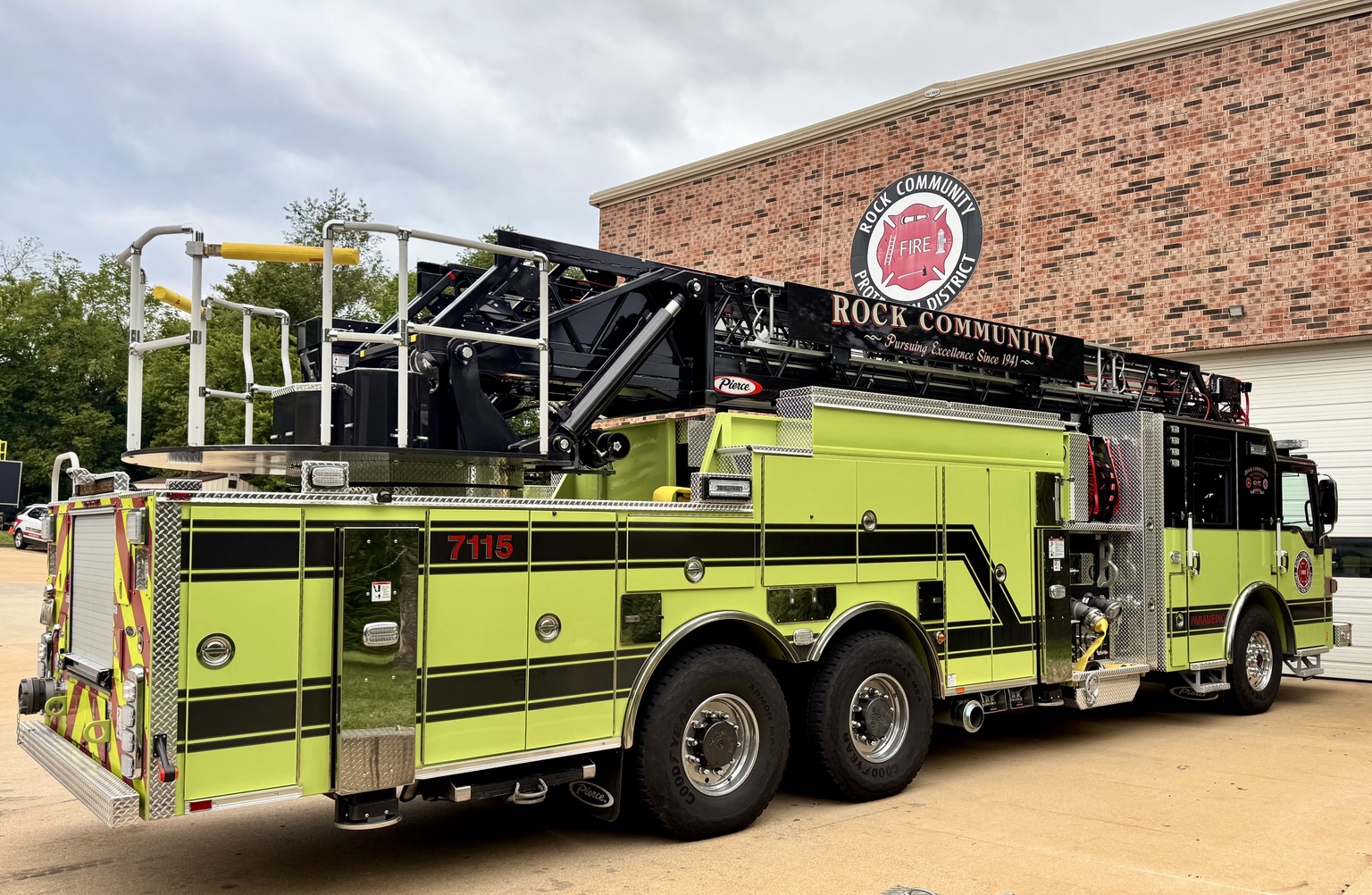 Rear three-quarter view of Rock Community Fire Protection District ladder truck 7115 outside the station