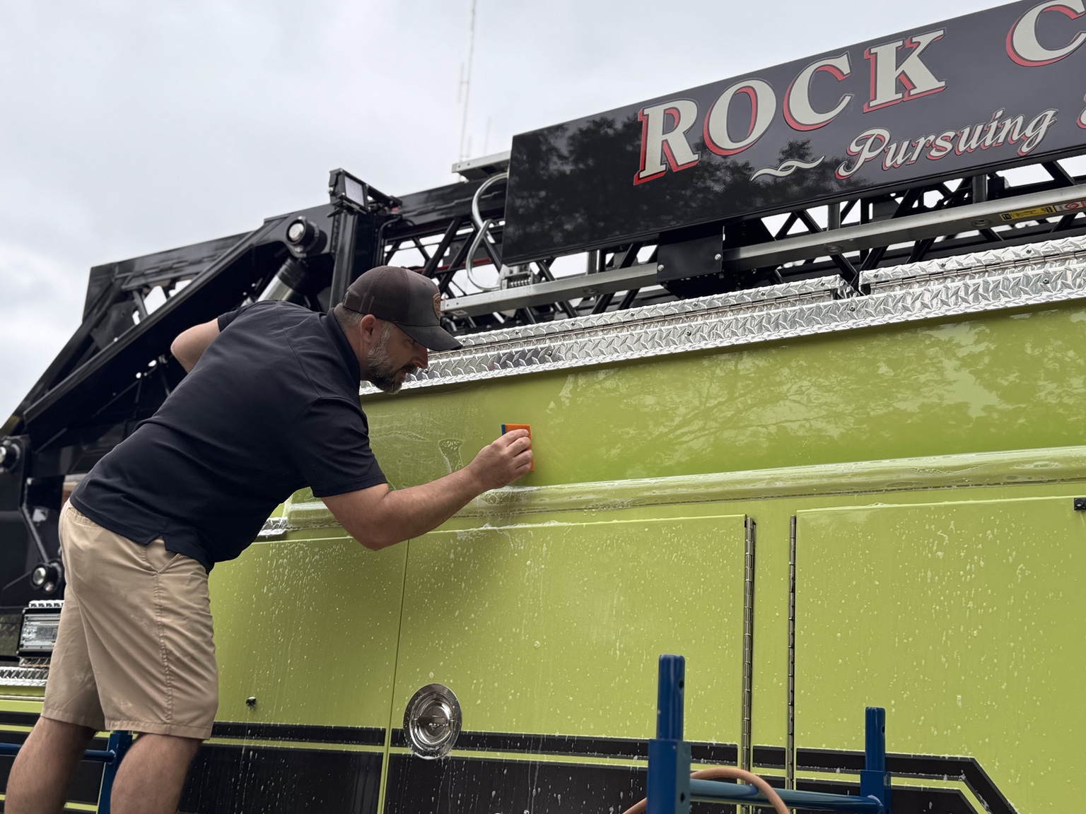 STL Auto Defenders installer applying PPF to an upper painted side panel of the Rock Community firetruck